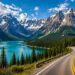 Scenic mountain road beside turquoise lake in Canada.