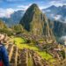 Traveler overlooking Machu Picchu ruins with mountain backdrop.