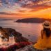 Traveler watching a stunning sunset over a coastal destination.