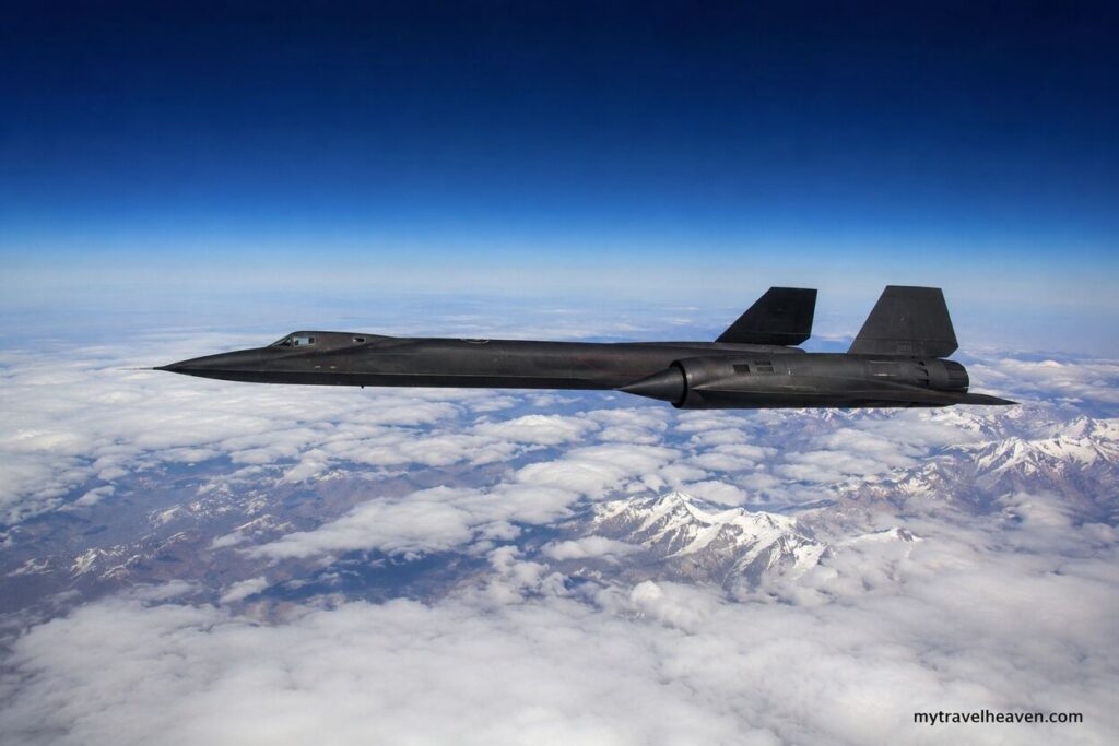 High-altitude aircraft flying above a vast layer of clouds and snow-capped mountains under a deep blue sky, representing the highest flight levels achieved by aviation.